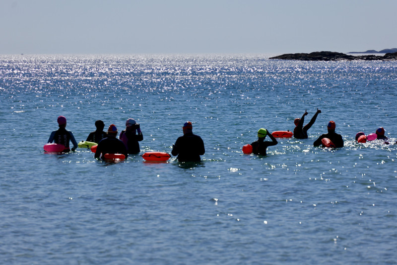 Group of people jumping over waves in the sea on Islay