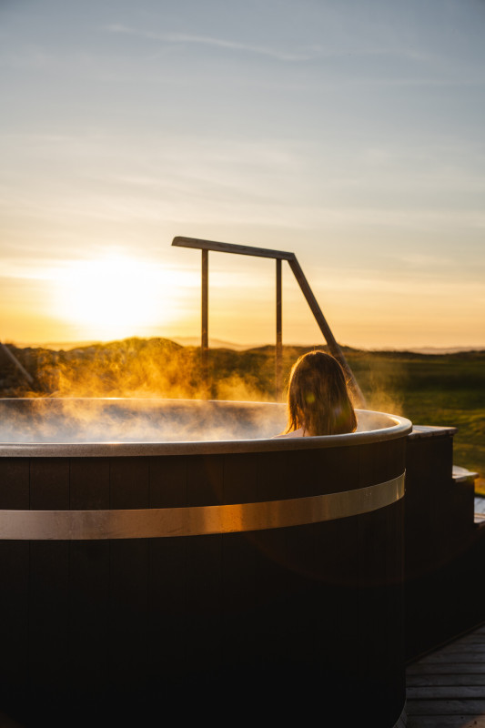 Woman sitting in the hot tub in The Wild Garden at Another Place. The Machrie