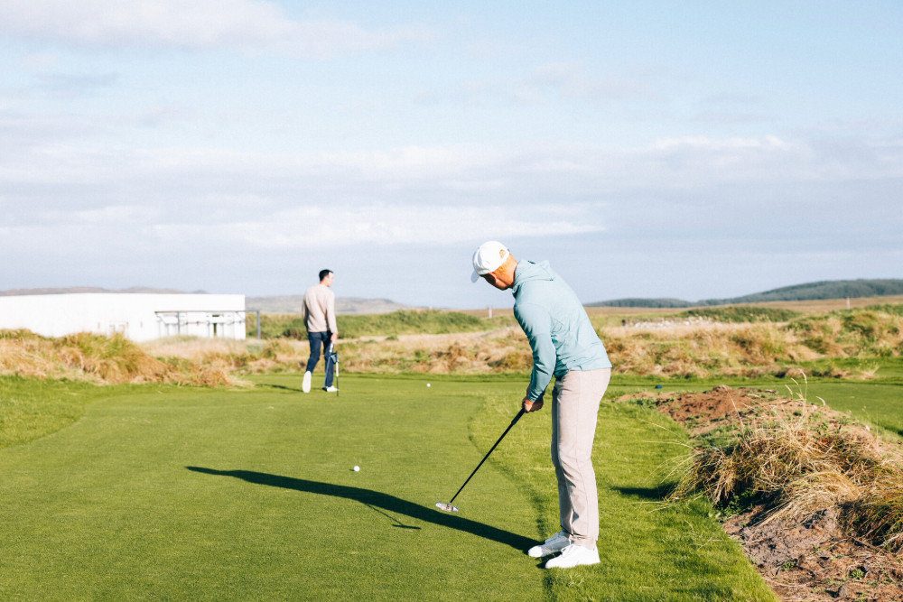 Two men playing on the social golf course at Another Place, The Machrie