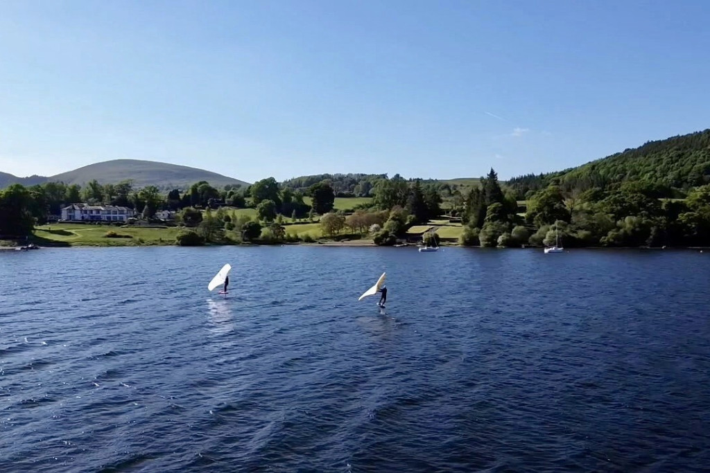 Two wing foilers gliding along Ullswater