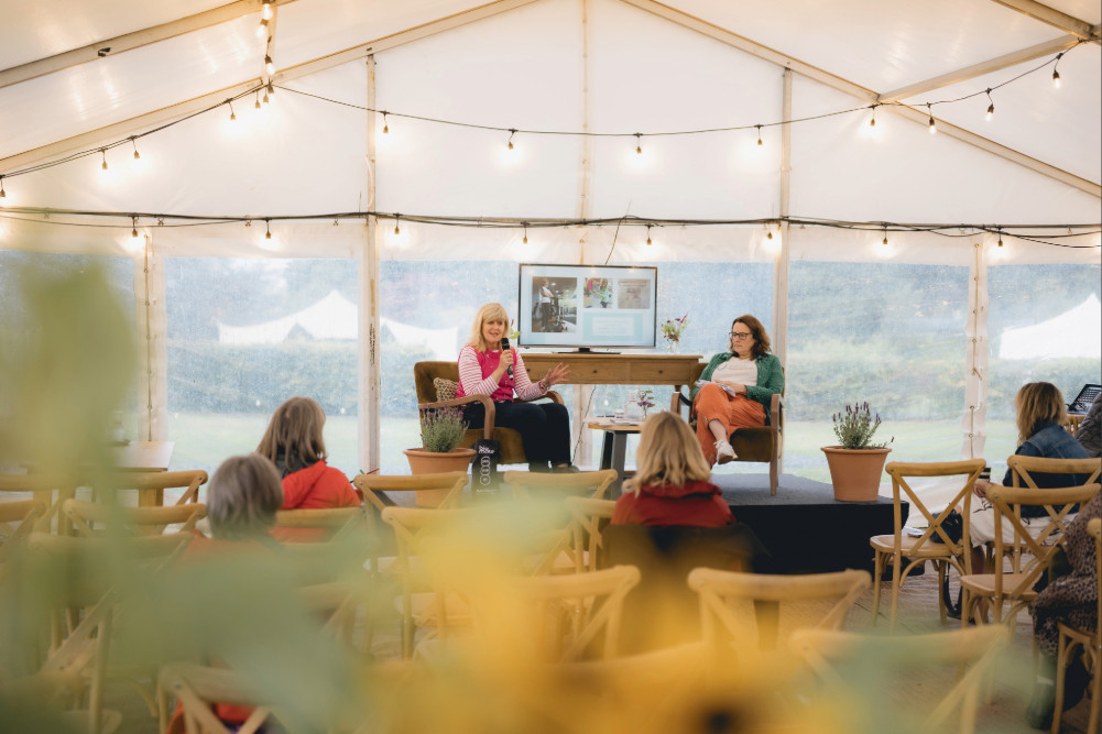 Jo Moseley speaking on stage at Fells & Flow at Another Place, the Lake