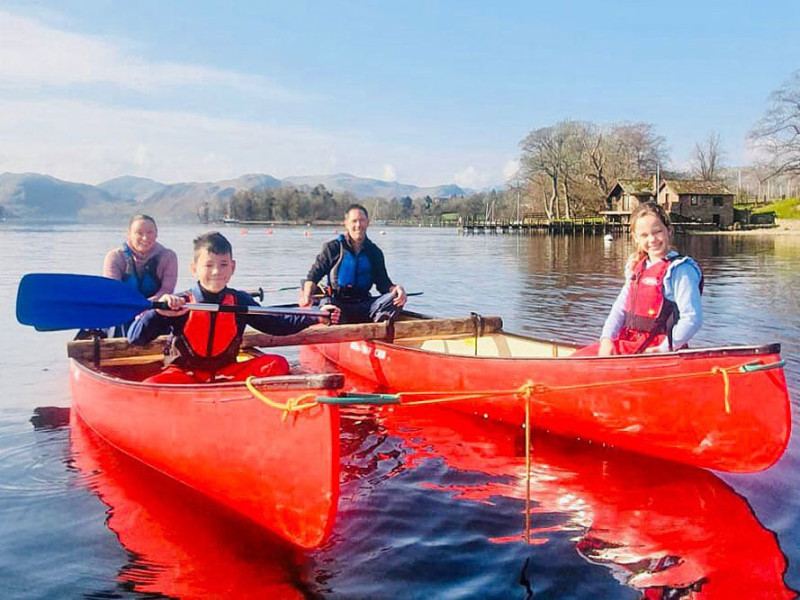 Family rafted canoeing on the lake