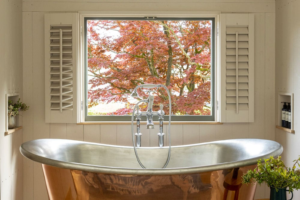 couple shepherd hut bath view