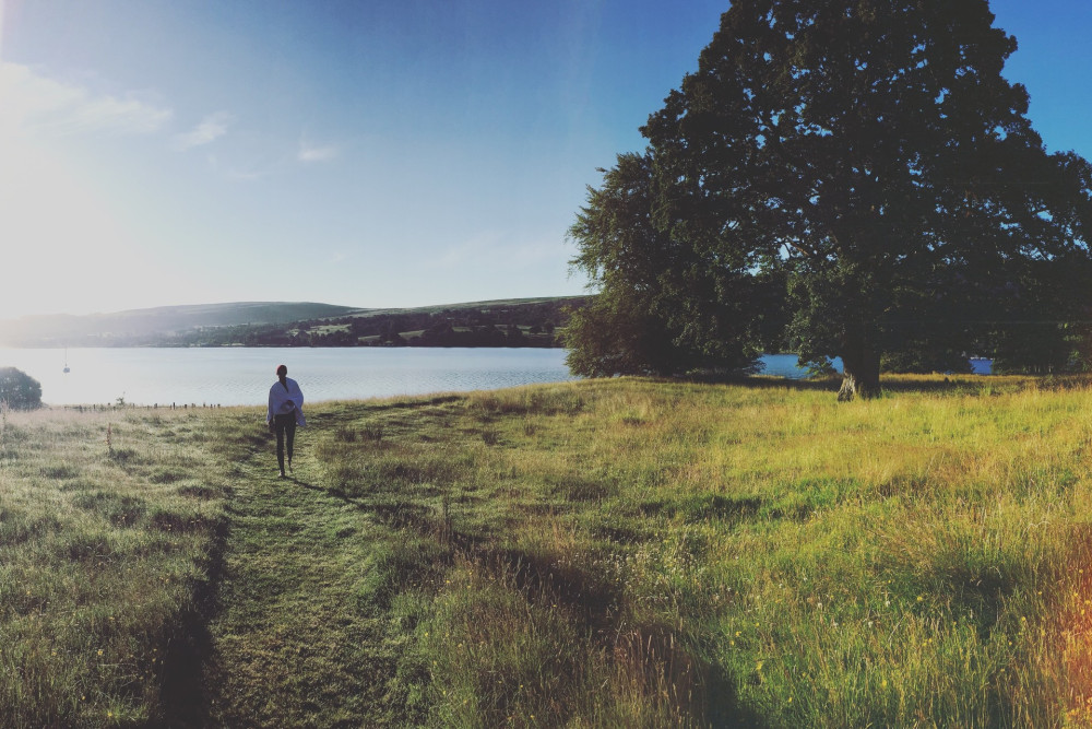 Woman walking on the shoreline at Another Place, The Lake