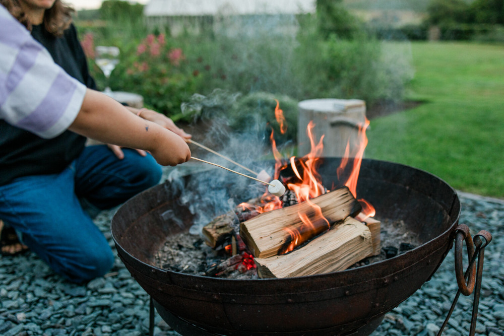 People around the firepit at Another Place, The Machrie with wisky in hand