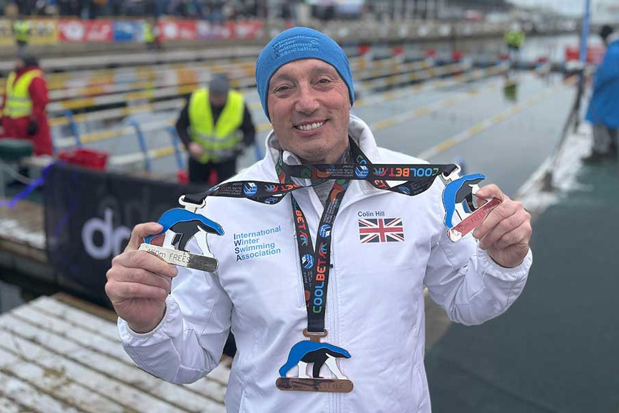Colin Hill holding his medals at the International Winter Swimming Association World Challenge